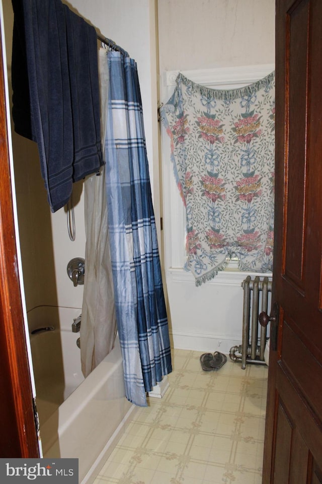 bathroom with radiator and shower / tub combo