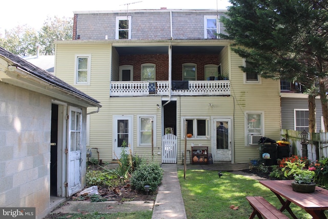 view of front of house featuring a balcony and a front lawn