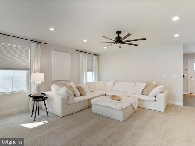 carpeted living room featuring a wealth of natural light and ceiling fan