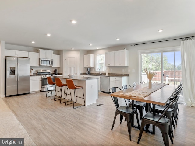 dining area featuring sink and light hardwood / wood-style flooring