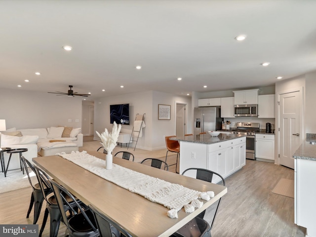 dining area featuring ceiling fan and light wood-type flooring