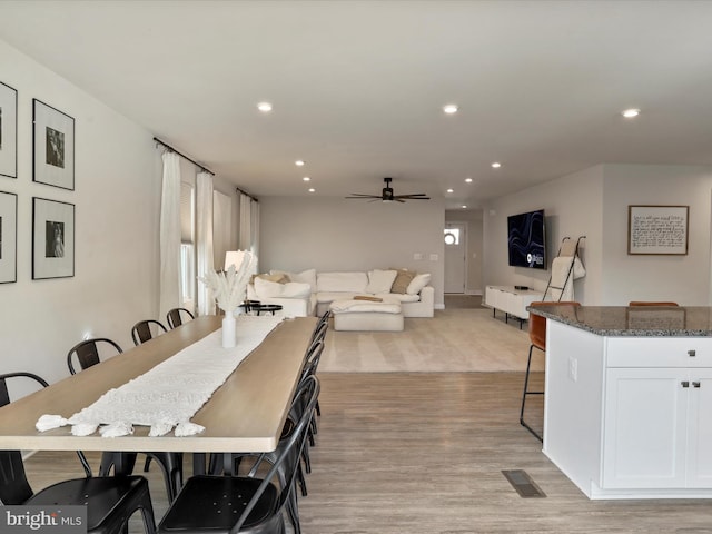 dining area with light hardwood / wood-style floors and ceiling fan