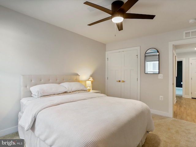 bedroom featuring ceiling fan, light colored carpet, and a closet