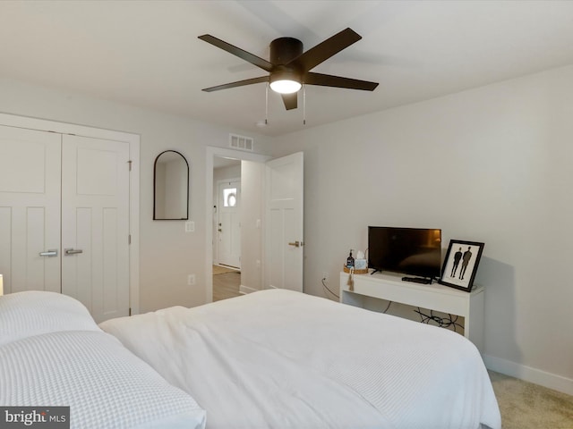 carpeted bedroom featuring ceiling fan and a closet