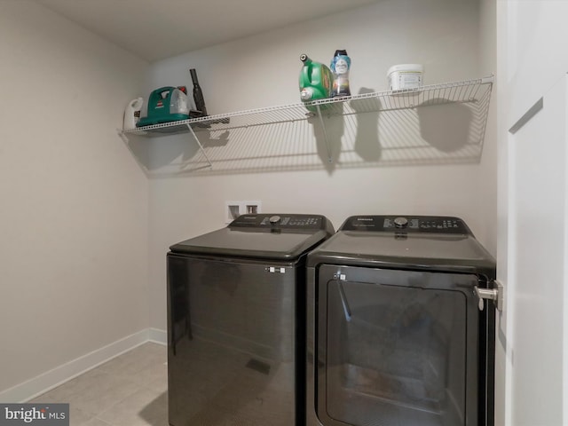 laundry room with light tile patterned floors and washing machine and dryer