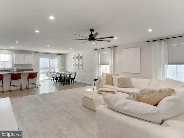 living room with ceiling fan and light hardwood / wood-style flooring