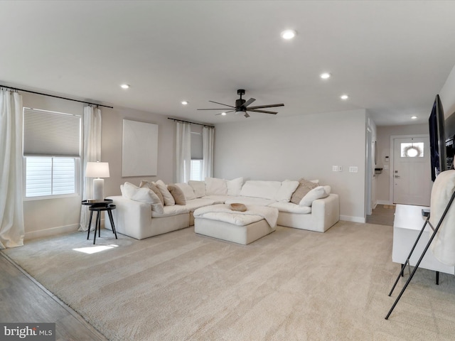 carpeted living room with ceiling fan