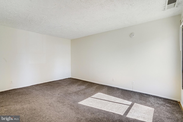 carpeted empty room with a textured ceiling