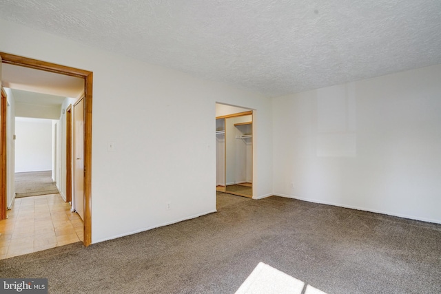 carpeted empty room with a textured ceiling