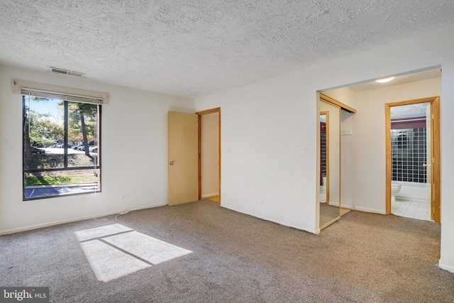 carpeted spare room with a textured ceiling