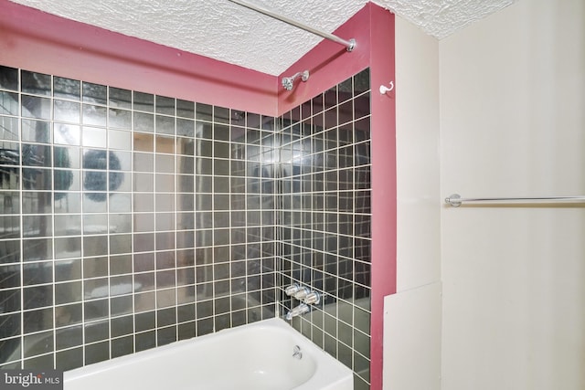 bathroom featuring tiled shower / bath combo and a textured ceiling