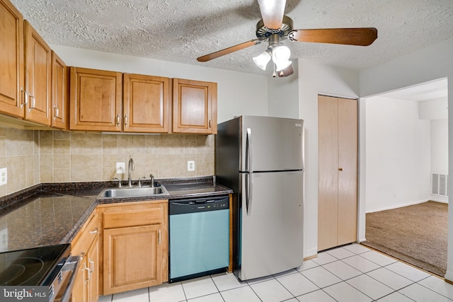 kitchen featuring tasteful backsplash, sink, a textured ceiling, stainless steel appliances, and light tile patterned floors