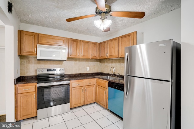 kitchen featuring backsplash, a textured ceiling, appliances with stainless steel finishes, and sink