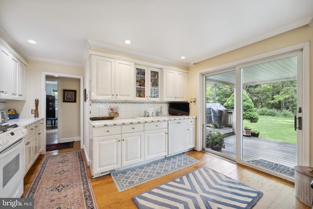 kitchen featuring light wood-type flooring, backsplash, white range with electric stovetop, and white cabinets