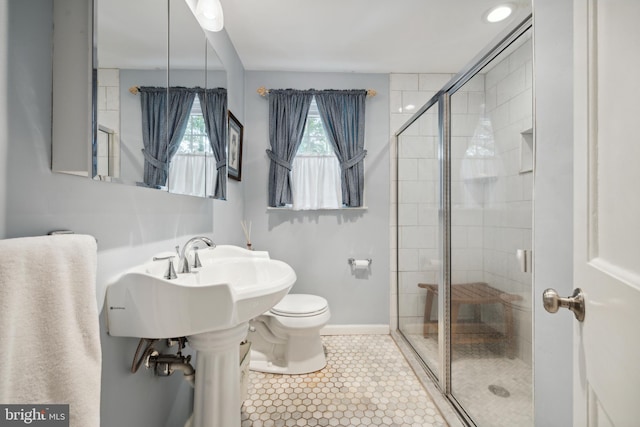 bathroom with tile patterned flooring, toilet, and a shower with shower door