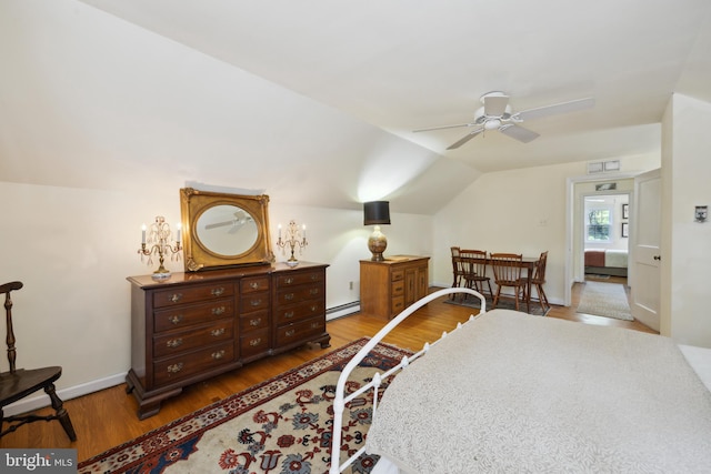 bedroom with wood-type flooring, vaulted ceiling, baseboard heating, and ceiling fan