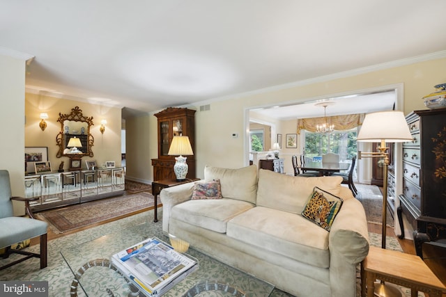 living room with crown molding and an inviting chandelier