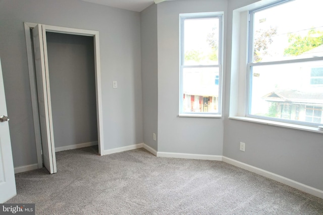 unfurnished bedroom with light carpet and multiple windows