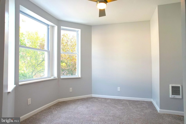 unfurnished room featuring ceiling fan, heating unit, plenty of natural light, and carpet