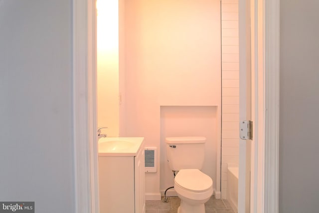 bathroom featuring vanity, heating unit, toilet, and tile patterned flooring