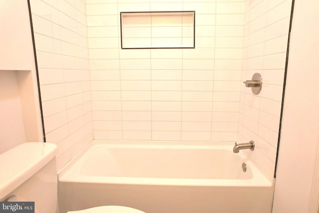 bathroom featuring tiled shower / bath and toilet