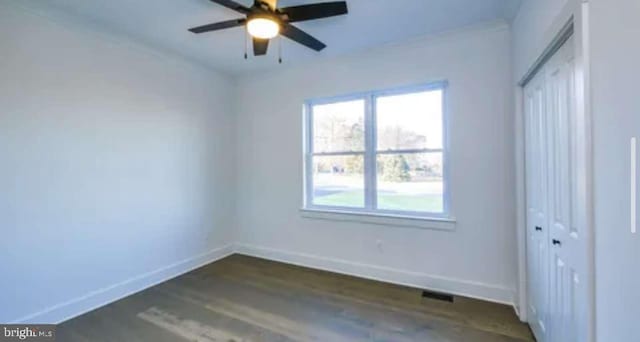 spare room with dark hardwood / wood-style floors and ceiling fan