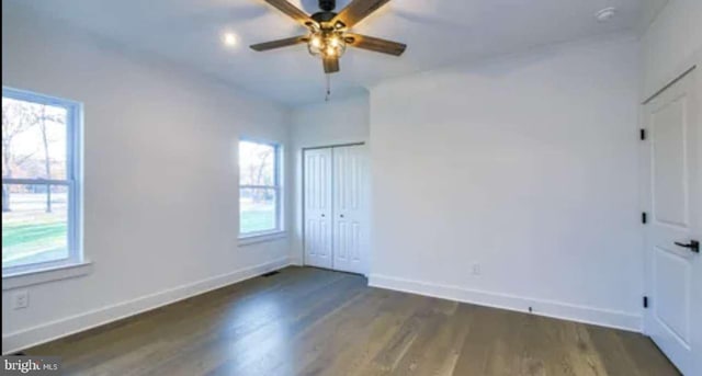 spare room featuring plenty of natural light, dark hardwood / wood-style floors, and ceiling fan