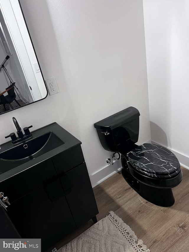 bathroom featuring vanity, toilet, and wood-type flooring