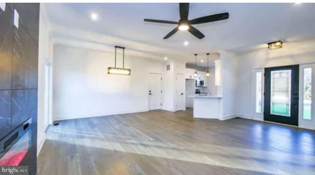 unfurnished living room featuring hardwood / wood-style floors and ceiling fan