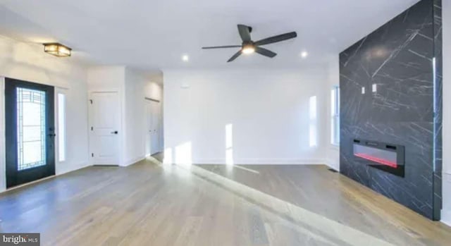 unfurnished living room with hardwood / wood-style floors and ceiling fan