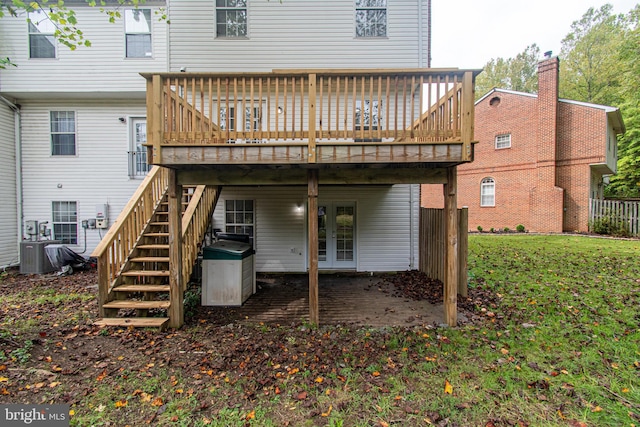 back of property with a lawn, central AC, and a wooden deck