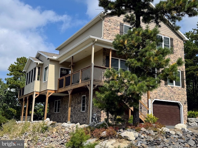 view of side of home with a garage and a balcony