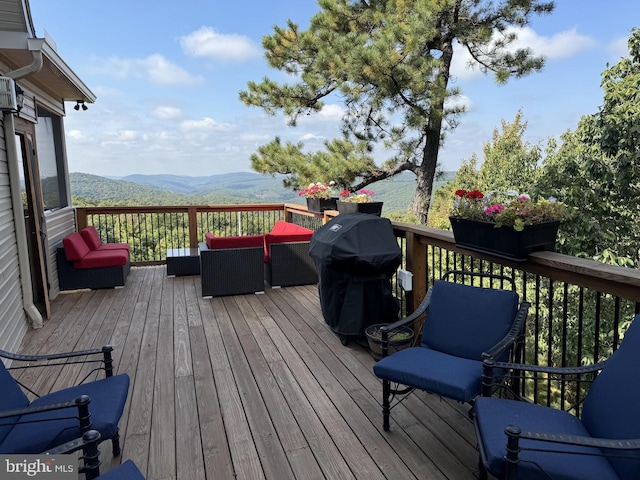 wooden terrace featuring a mountain view, an outdoor hangout area, and grilling area