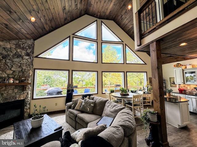 living room with hardwood / wood-style flooring, a stone fireplace, wood ceiling, and high vaulted ceiling