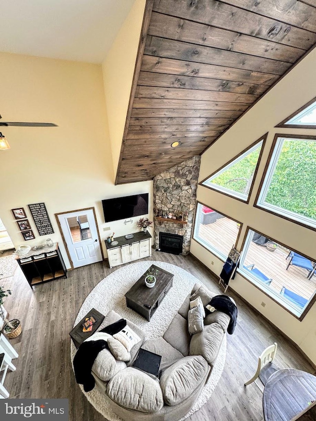 living room with lofted ceiling, wooden ceiling, ceiling fan, a fireplace, and wood-type flooring