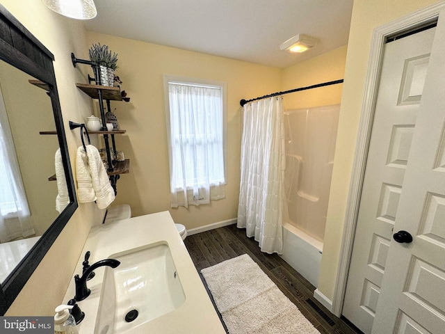 full bathroom with shower / tub combo with curtain, hardwood / wood-style flooring, toilet, and sink