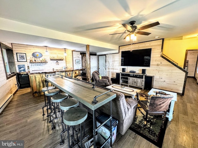 living room with wooden walls, dark hardwood / wood-style flooring, ceiling fan, and pool table