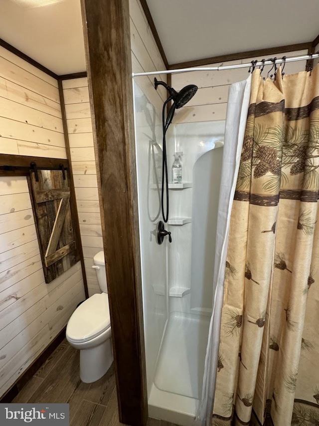 bathroom with a shower with curtain, wood-type flooring, toilet, and wooden walls