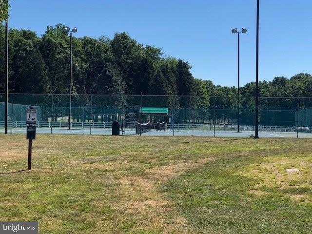 view of tennis court with a yard