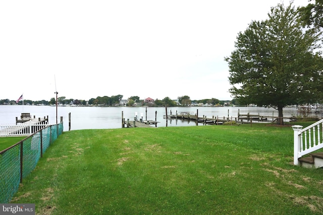 dock area with a lawn and a water view