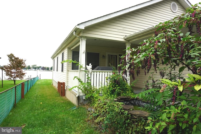 view of home's exterior featuring a lawn and covered porch