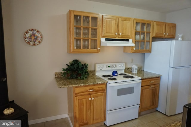 kitchen featuring light stone counters, light tile patterned floors, and white appliances