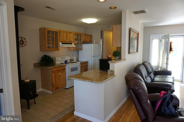 kitchen featuring light hardwood / wood-style floors, light stone countertops, white appliances, and kitchen peninsula