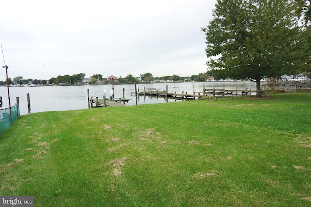 view of dock with a water view and a lawn