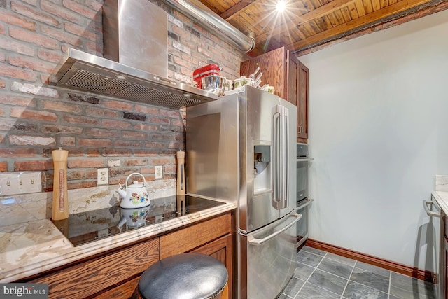 kitchen featuring brown cabinetry, wood ceiling, wall chimney range hood, and stainless steel refrigerator with ice dispenser