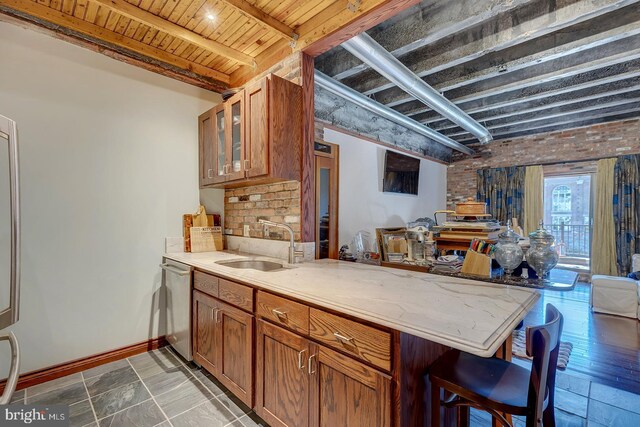 kitchen featuring a peninsula, brown cabinets, dishwasher, wood ceiling, and a sink
