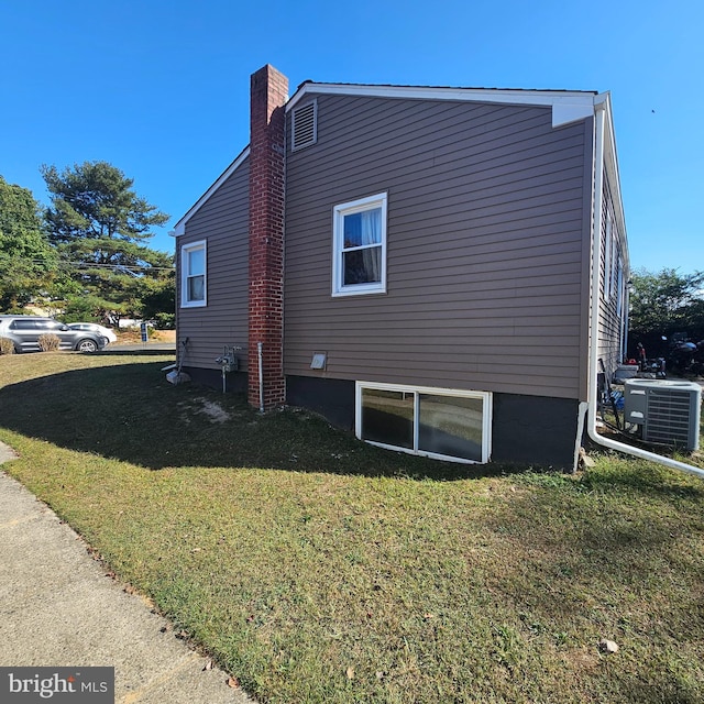 view of side of home featuring a lawn and central AC unit