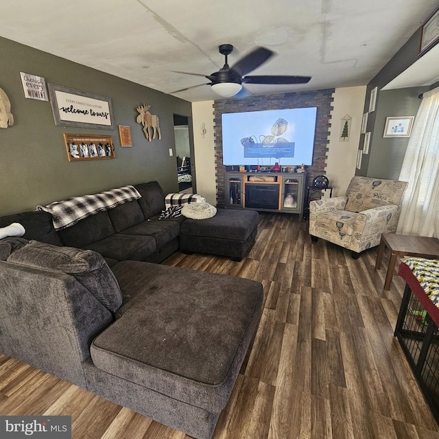 cinema room with ceiling fan and wood-type flooring