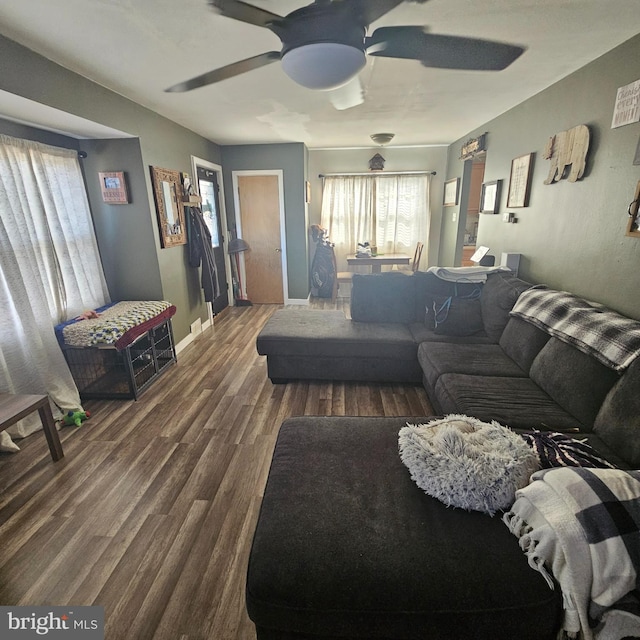 living room featuring ceiling fan and dark hardwood / wood-style floors