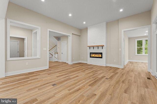 unfurnished living room with light hardwood / wood-style floors and a fireplace